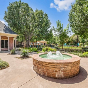 fountain in a courtyard surrounded by mature landscaping at Villas