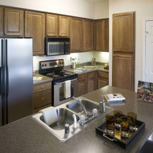 kitchen area of villas of spring creek with stainless refrigerator, stove and microwave